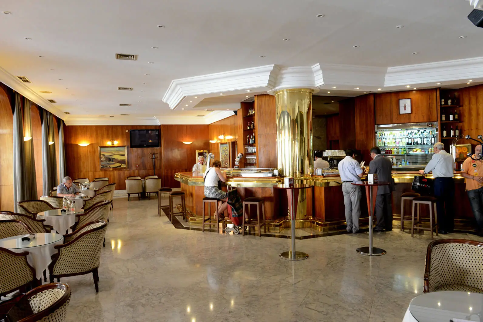 Vista amplia del salón de la cafetería, mostrando el suelo de mármol y la amplitud del espacio para los clientes.