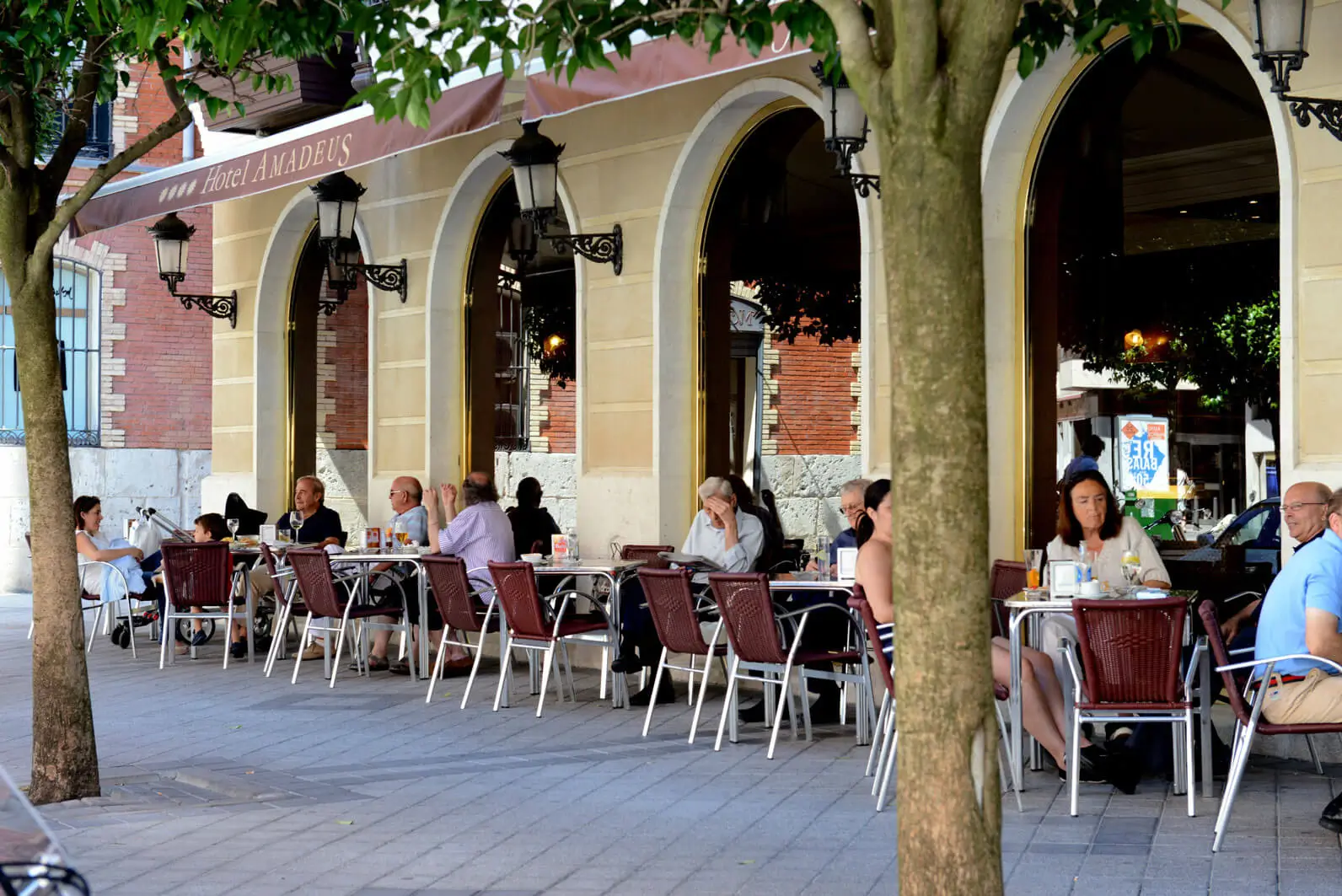 Terraza exterior de la cafetería del Hotel Mozart en Valladolid, situada en una zona peatonal céntrica con mesas al aire libre.